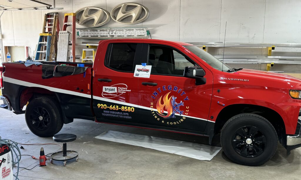 Truck graphics installation in garage.